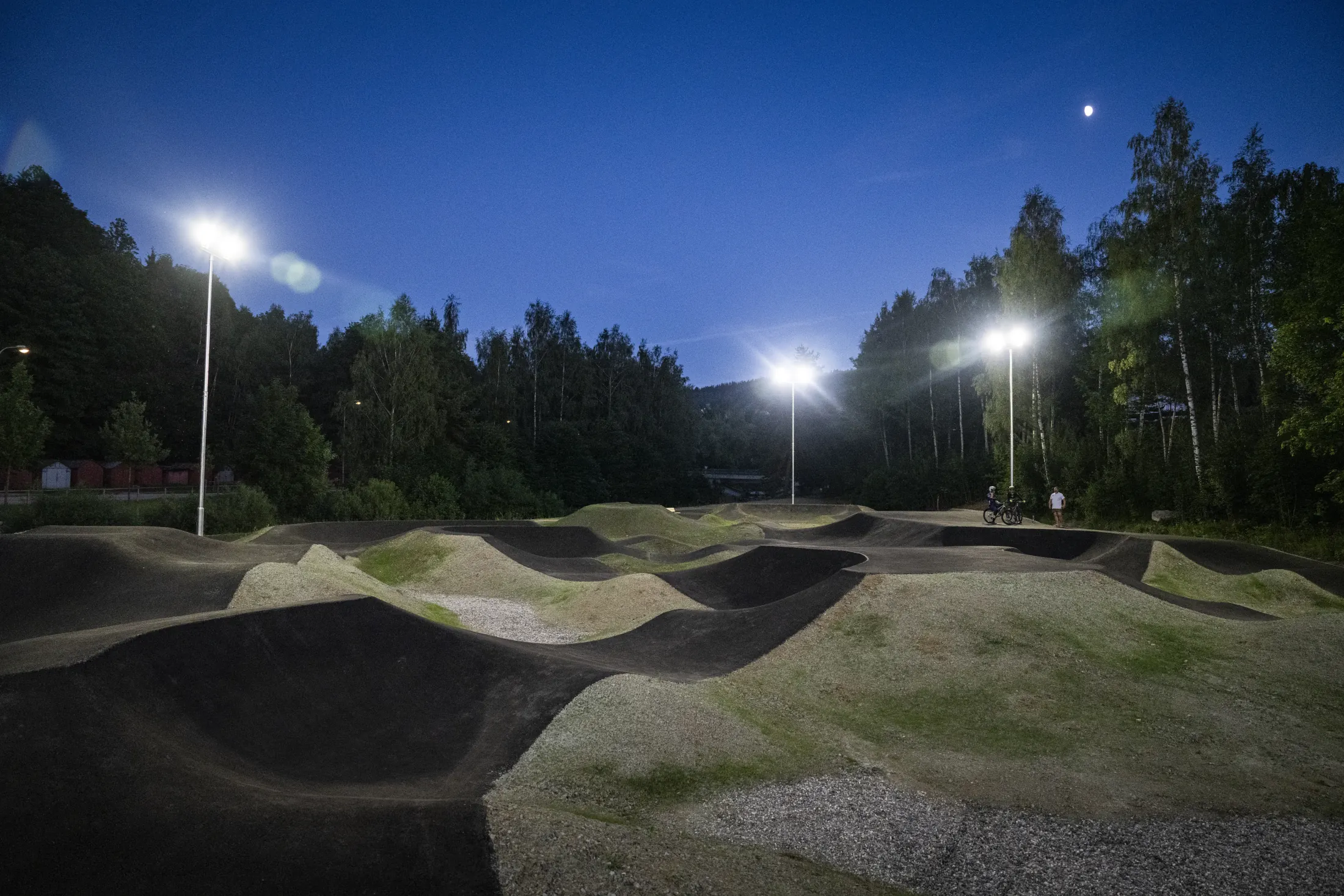 Pumptrack ve Vimperku za soumraku, osvětlený třemi lampami